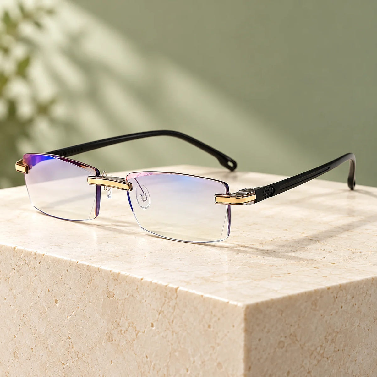 TR90 rimless glasses with gold-tone bridge and black temples on an ivory stone plinth
